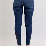 Blue jeans worn by a person on a light gray background