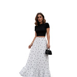 Person wearing a white floral skirt with a plain background