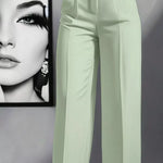 Light green pants worn by a person with a framed black and white portrait in the background.