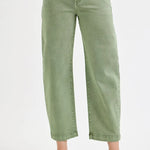 Green jeans worn by a person on a white background