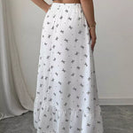 White skirt with black patterns worn by a person on a neutral background