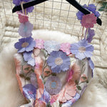 Floral headband with colorful flowers on a hanger against a grid background