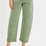 Person wearing green wide-leg jeans on a white background