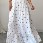 White skirt with black patterns worn by a person on a neutral background