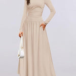 Woman wearing a beige long-sleeve dress on a light gray background
