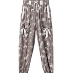 Patterned pants on a hanger against a plain background